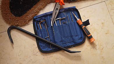 Set of burglary tools on floor near welcome mat
