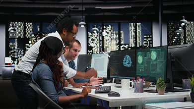 Team of programmers in office working together to block hacker intrusion