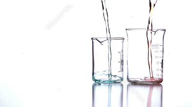 Blue and red liquid pouring into beakers