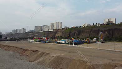 Lively beach scene with rides and families, Scenic shoreline bustling with activities and relaxing ocean view