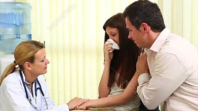Doctor talking to a crying woman in a waiting room