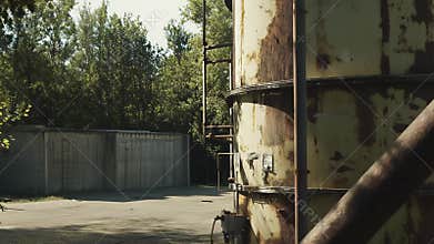Abandoned industrial landscape with rusty silo and concrete structure