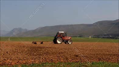 Red tractor plowing