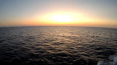 Expansive ocean view at sunset, showcasing vibrant colors reflecting on calm water surface, capturing the serene transition