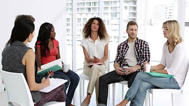 Cheerful psychologist leading group of people