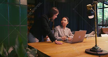 Businesswomen collaborate on modern laptop and exchange ideas