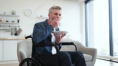 Man in wheelchair enjoying healthy salad in modern kitchen setting