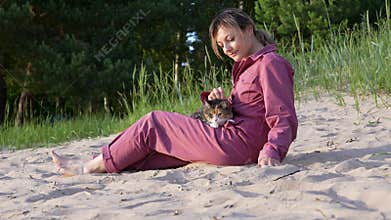 Woman with cat relax on beach by sea shore. Show sand to feline distracting from travel anxiety