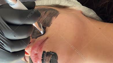 Young woman getting carbon laser facial at beauty clinic. Professional skincare