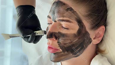 Young woman getting carbon laser facial at beauty clinic. Professional skincare