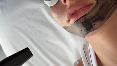 Young woman getting carbon laser facial at beauty clinic. Professional skincare