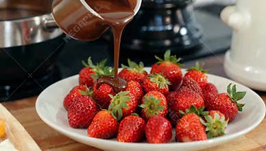 Delicious strawberries being drizzled with rich melted chocolate for a sweet dessert treat