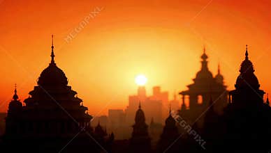 Silhouette of city buildings and temples against a vibrant orange sunset sky background