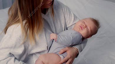 Loving mother comforts her crying baby in a cozy home environment