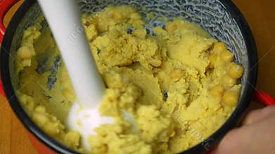 Blending chickpeas in a saucepan. Making homemade hummus