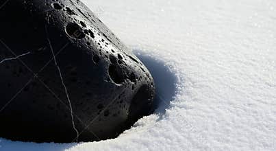 A Dark Rock Emerges from the Snowy Landscape