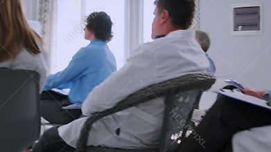 Medical staff listening to lecture and taking notes