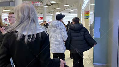 Families Walk Through a Shopping Center in Winter Coats While Enjoying Their Time Together