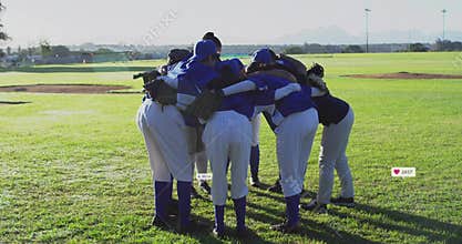 Huddling eight female baseball players sharing pep talk on field, with team jerseys and gloves