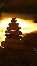 Stones balance sunset, serene rock cairn stacked against golden ocean light at dusk with peaceful copy space.