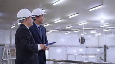 Executive manager and engineer inspecting food processing factory, businessman discussing quality control and production, team in