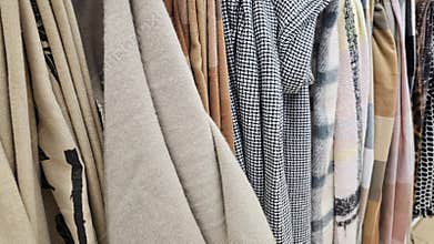 Display of various fabric textures and patterns in a clothing store during daytime shopping concept