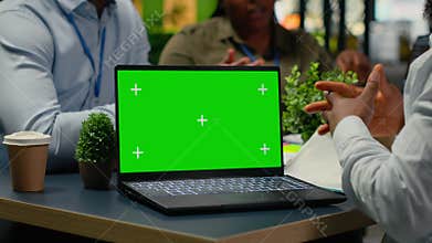 Green screen laptop used by programmers in startup office leveraging AI tech