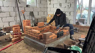 Stove maker builds a heating stove. Wide shot