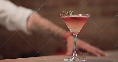 Barman prepares cocktail with fresh ingredients in