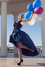 Beautiful elegant girl with dark hair with colorful baloons