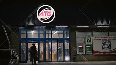 People enter and exit through automatic entrance doors ATB store