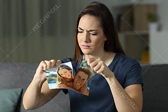 Angry girl breaking a couple photo after breakup
