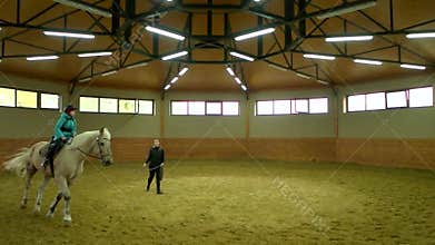 Slow motion kid boy riding horse indoor.