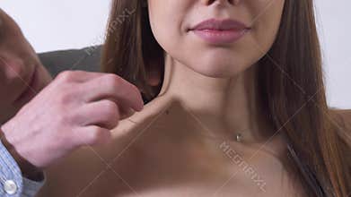 Happy handsome man put necklace aruond womans beautiful neck