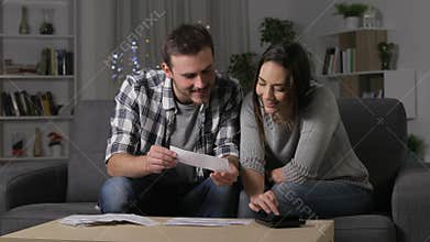 Happy couple accounting checking receipts in the night