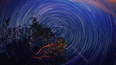 Moving star trails in night sky circular Timelapse. The Milky Way galaxy rotating over the tree range in summer time UHD