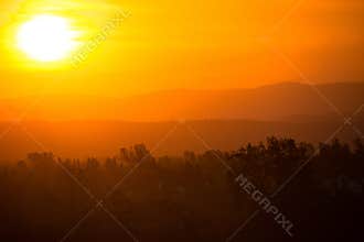 Hazy colorful mountain sunrise in Redding California, with orange, red and yellow colors