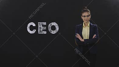 Businesswoman looking at camera and touching glasses, with inscription `CEO`