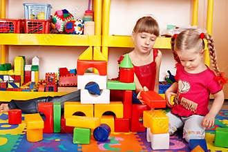 Child with block in play room.