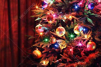 Christmas tree with balls, glowing garland and tinsel