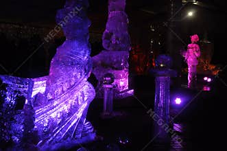 Ice sculptures in blue and purple lights at night