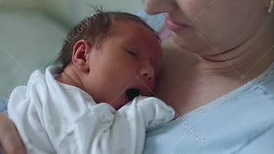 Newborn baby sleeping peacefully over the mother chest