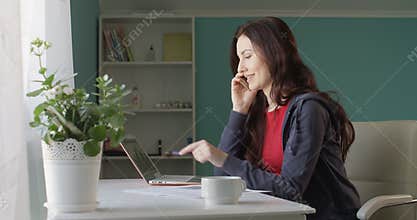 Attractive Brunette Woman Freelancer Working from Home Computer and Talking on the Phone Rejoicing Success with Sales
