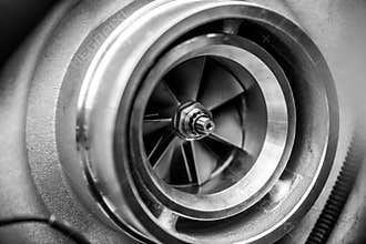 Close up detail of a diesel engine turbocharger with fan blades and center axle - selective focus on center axle