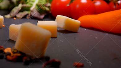 Cubes of Parmesan cheese fall to the surface of the table