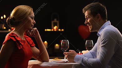 Upset lady looking at boyfriend scrolling smartphone, bad date, gadget addiction