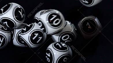 Black and white lottery balls in a machine slow motion