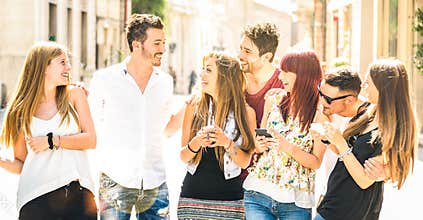 Best friends group having fun together walking on city street - Technology interaction concept in everyday lifestyle with