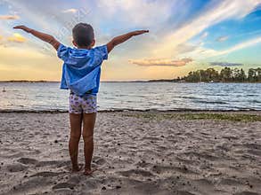 Boy spreading arms on beach