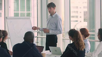 Confident serious male business coach speaker give corporate flipchart presentation